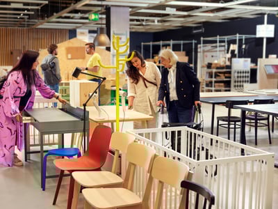 Kupci si ogledujejo rabljeno pohištvo IKEA v Kotičku enkratnih priložnosti