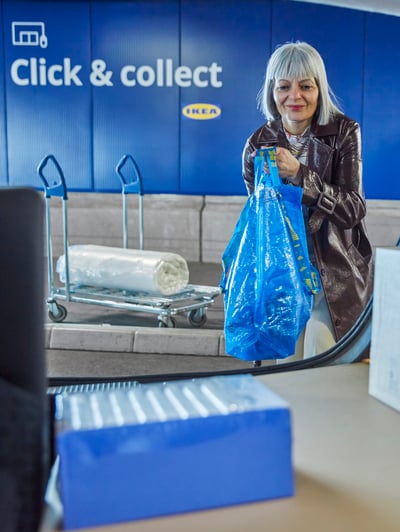 Žena unosi IKEA proizvode u stražnji dio vozila.
