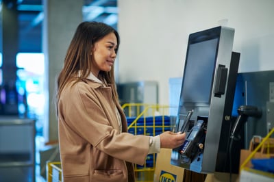 Osoba stoji pored uređaja za plaćanje putem usluge Shop&Go