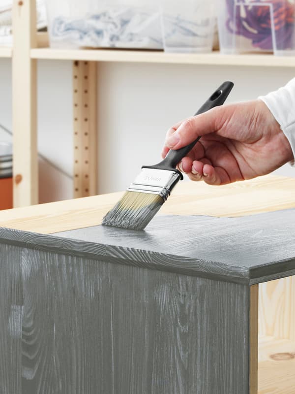 Wooden furniture being painted with grey paint 